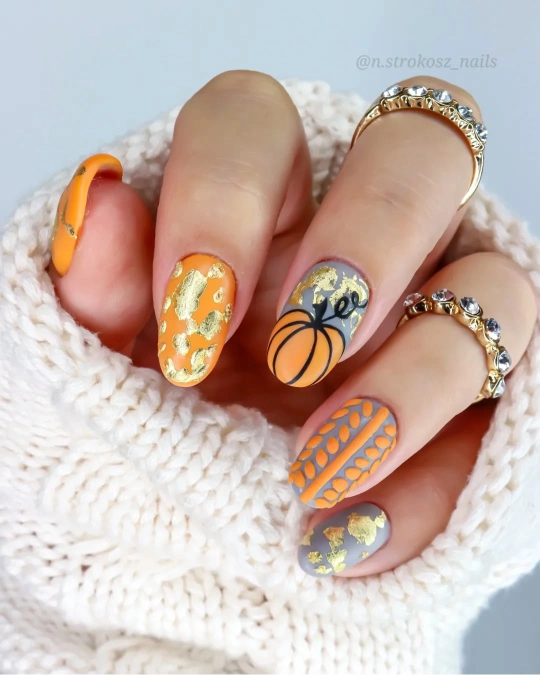 Mauve oval nails with orange pumpkins and gold foil accents