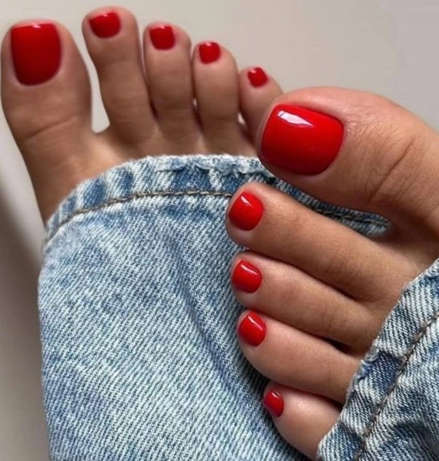 Classic glossy red pedicure with denim