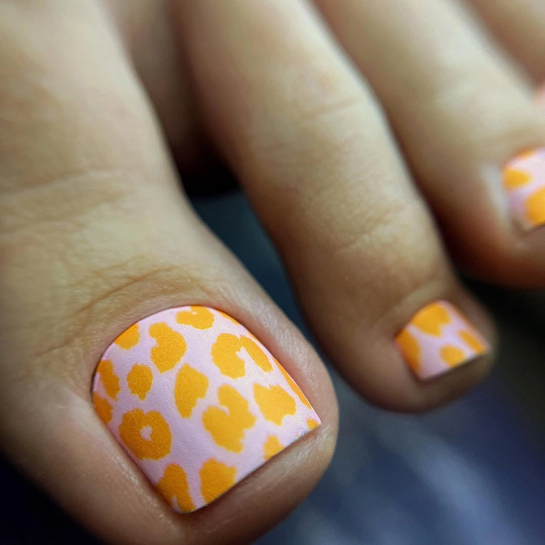 Pink toenails with orange animal spots