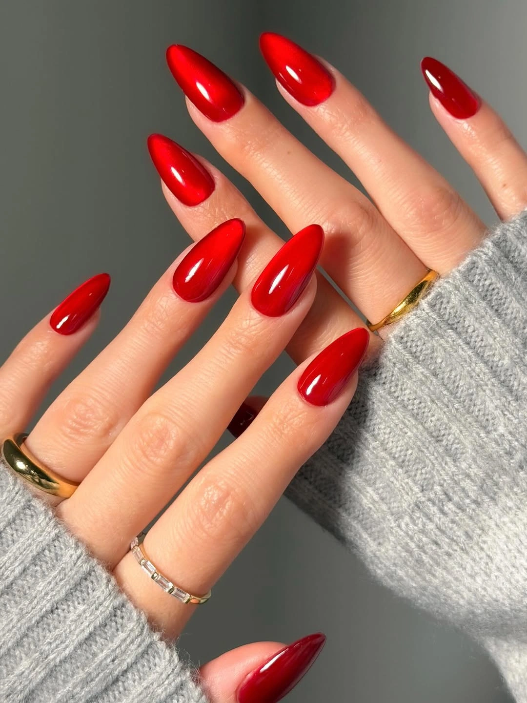 Classic glossy red almond nails with gray sleeves