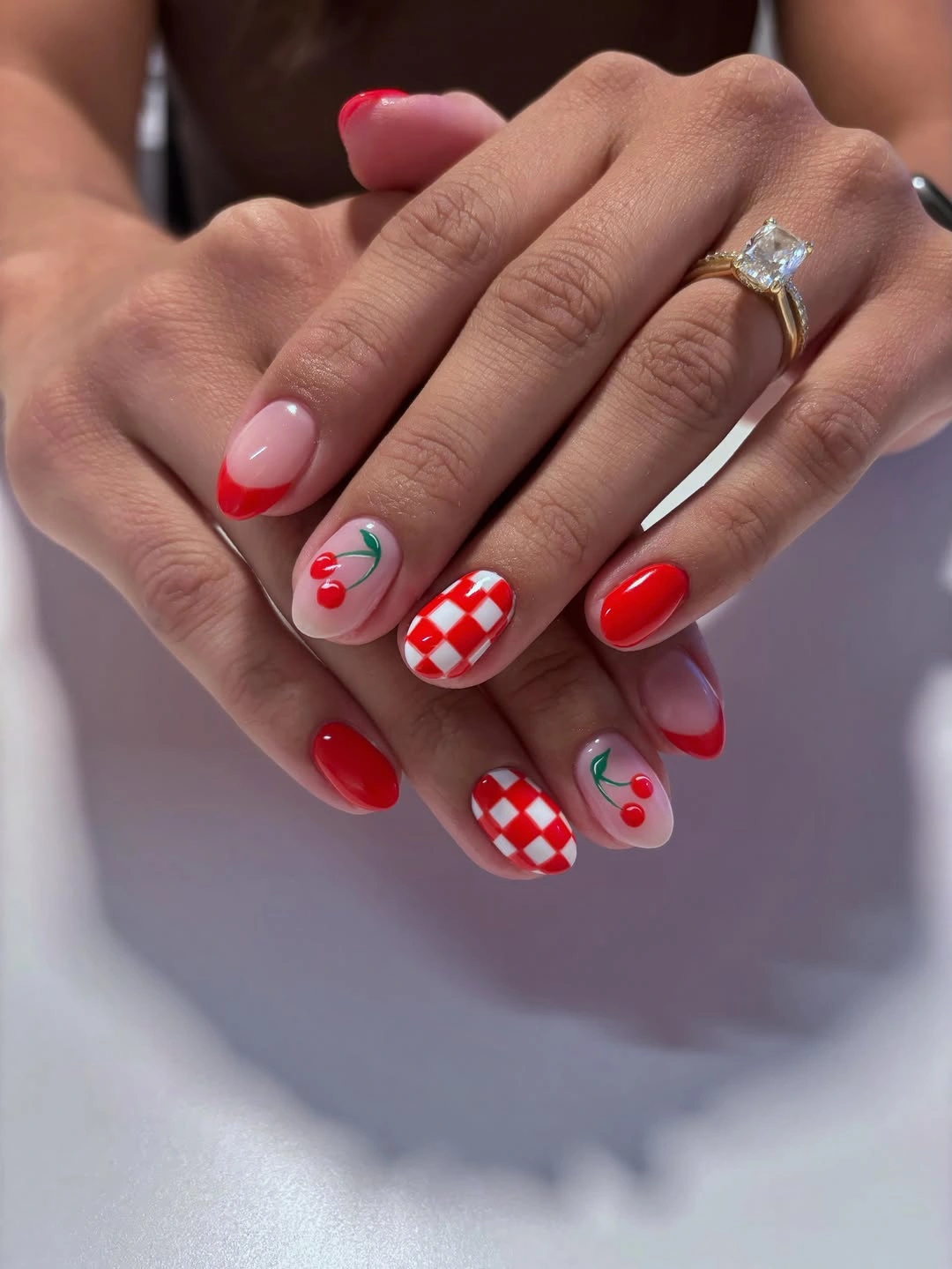 Short cherry red nails with checkerboard accent art