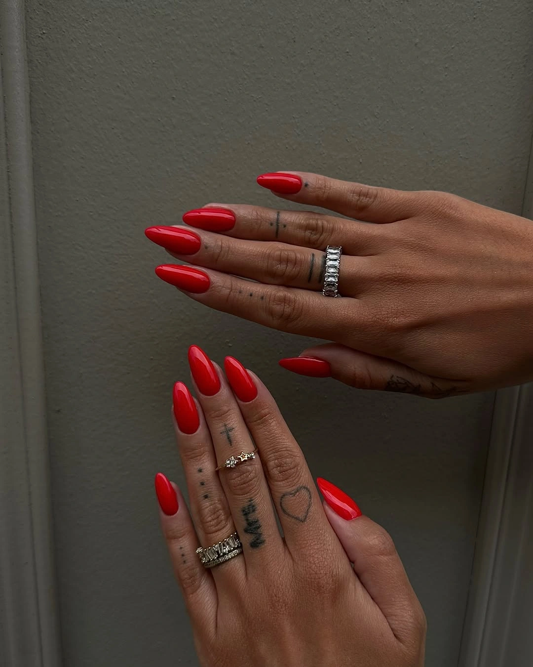 Matching bright red almond nails on both hands