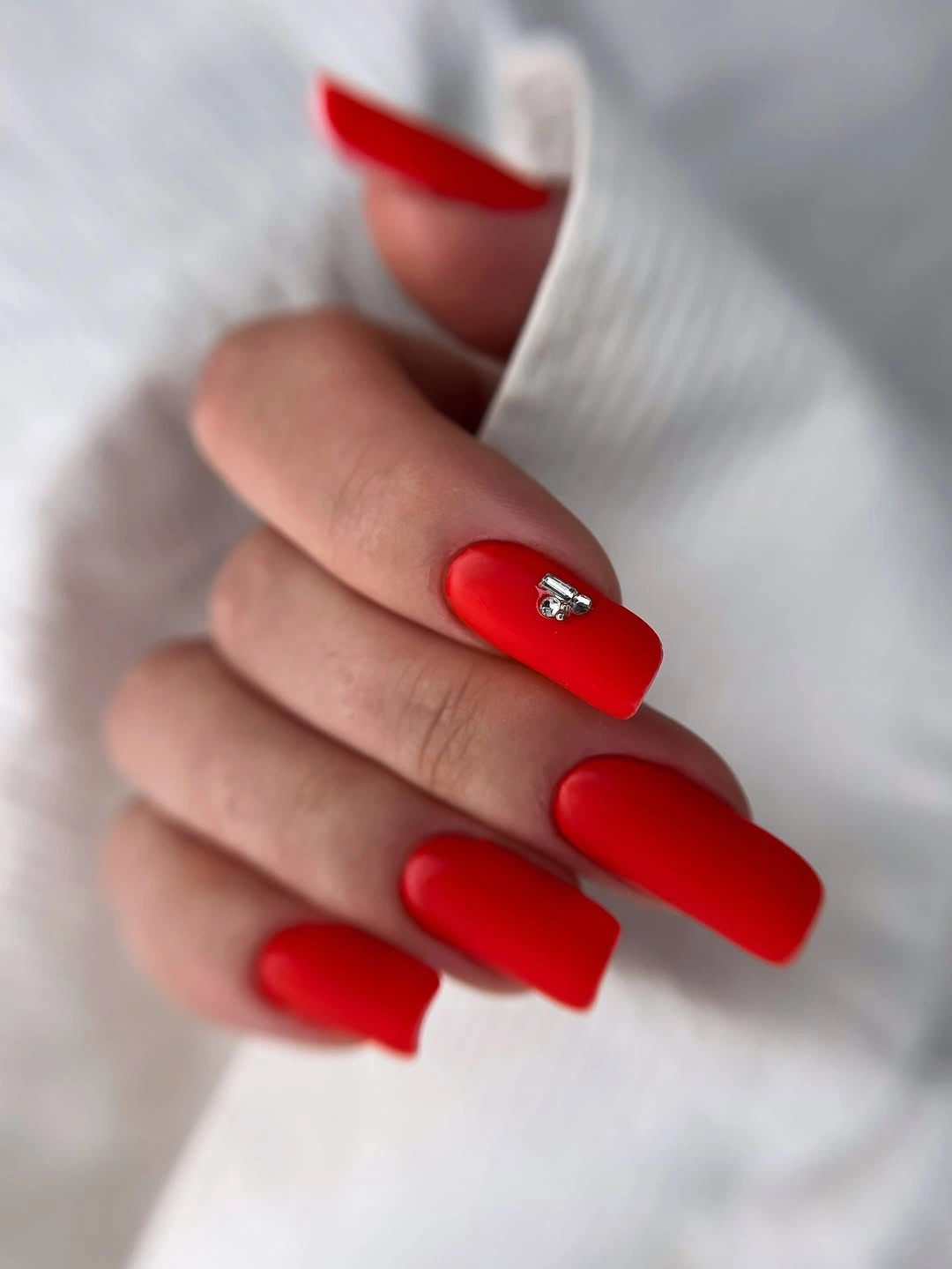 Matte red coffin nails with tiny crystal accent