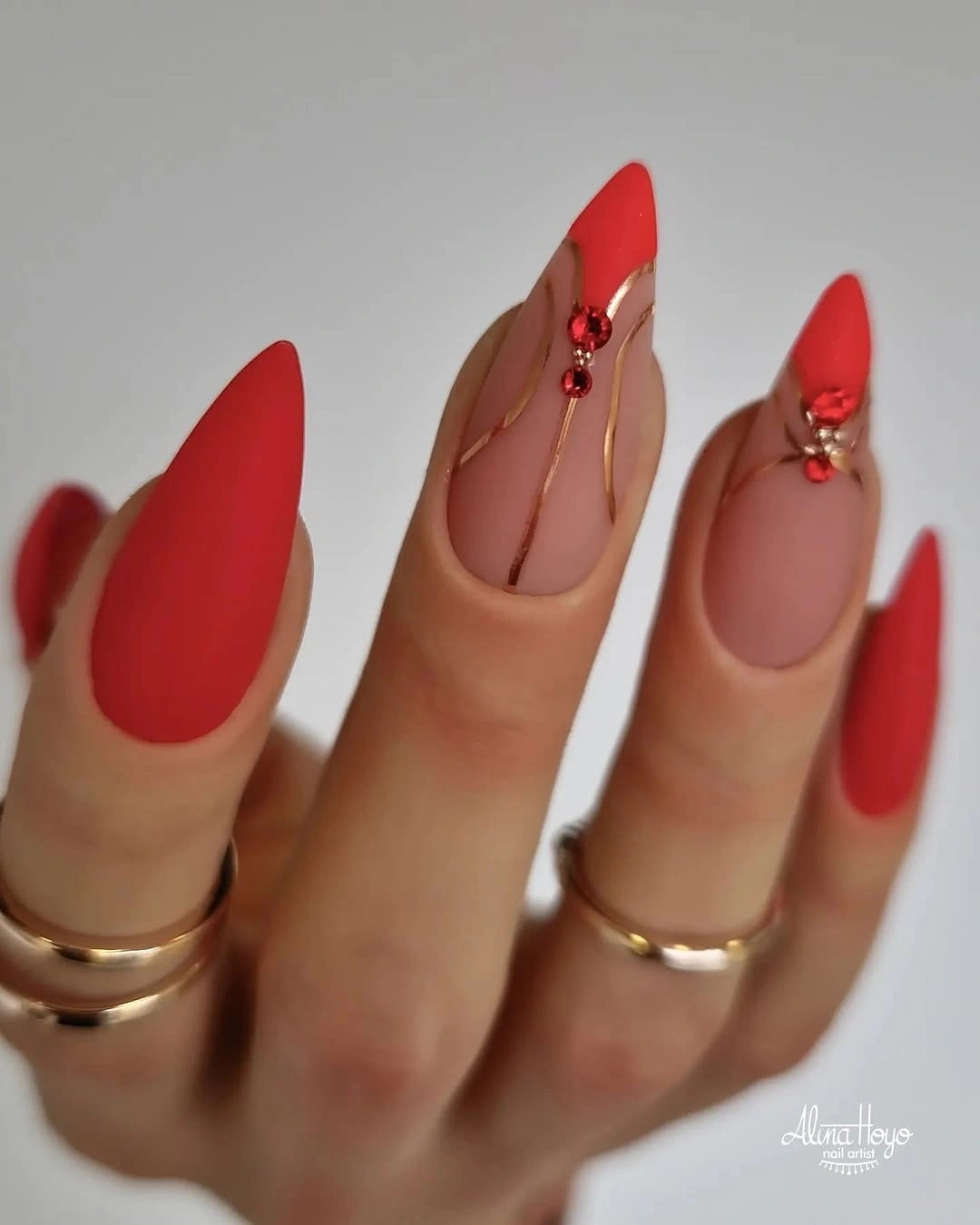 Matte coral red almond nails with gold line accents