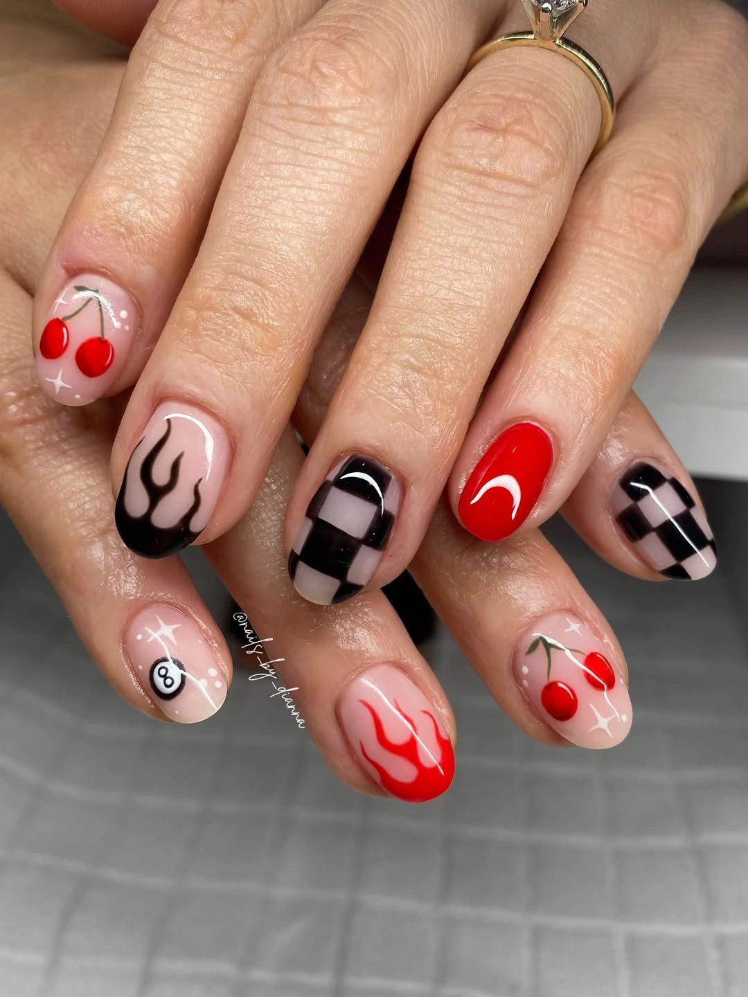Short red nails with cherries flames and checkers