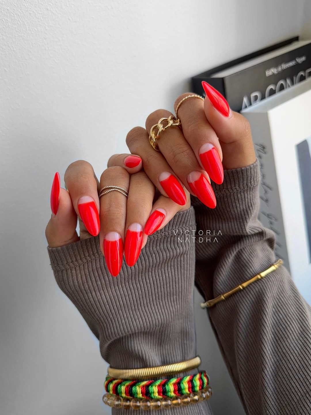 Bright red almond nails with bare half moon bases
