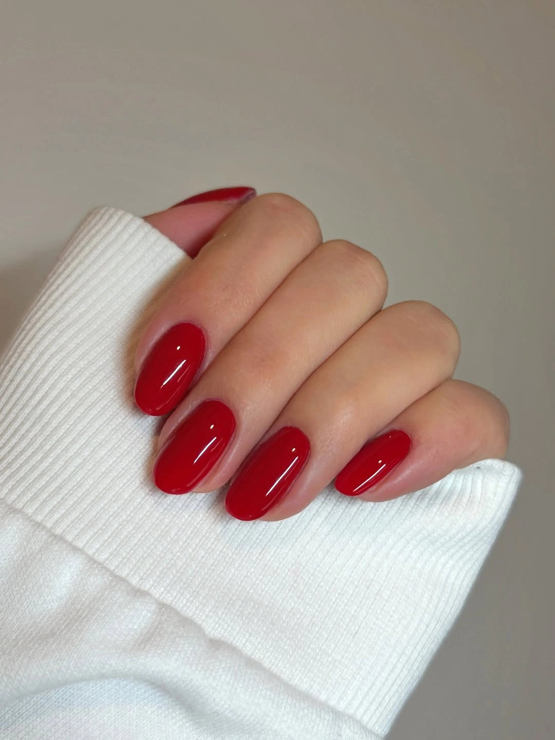 Short glossy red rounded nails with white sleeve