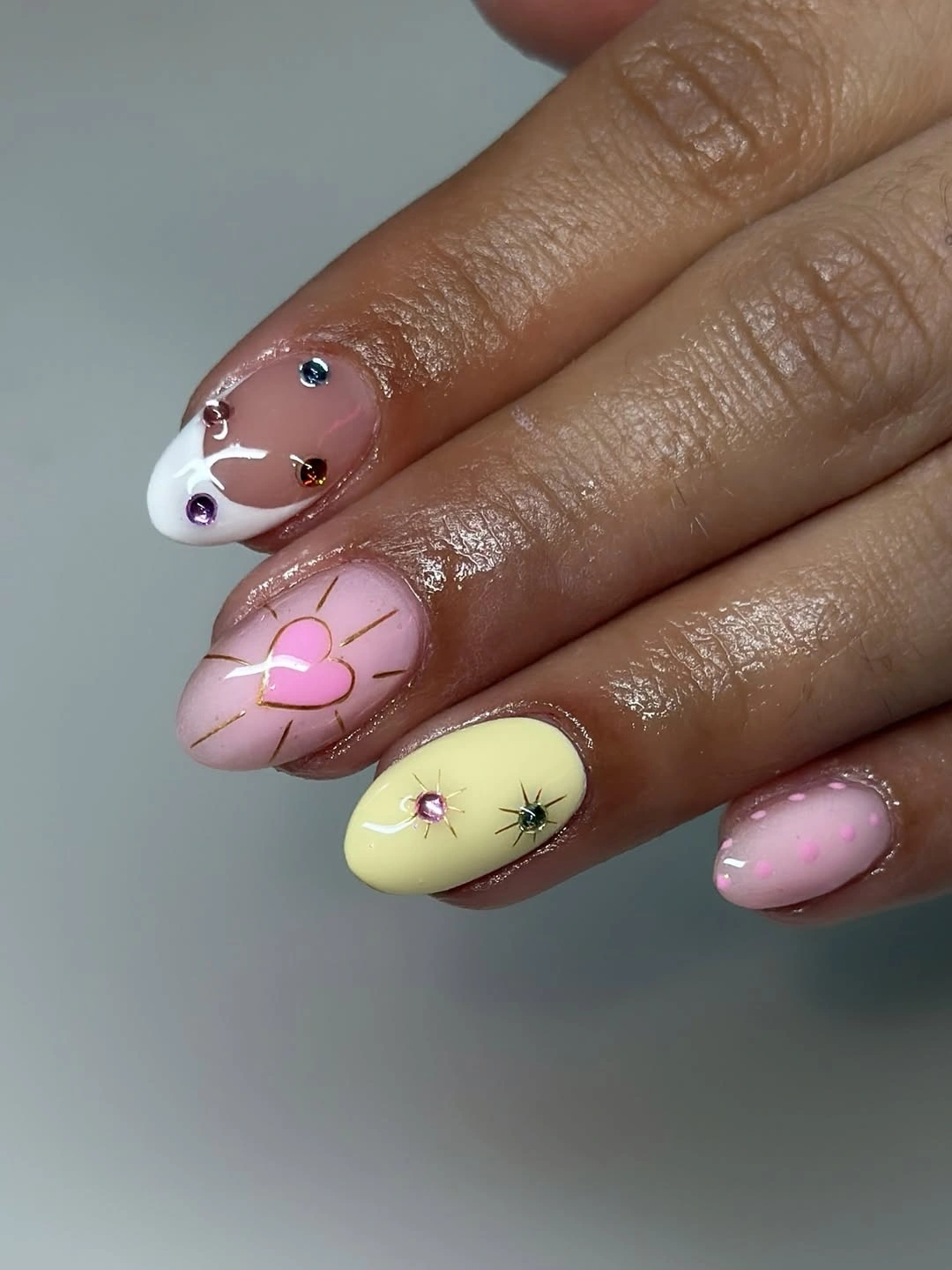 Short almond nails with pastel yellow flowers and tiny dots