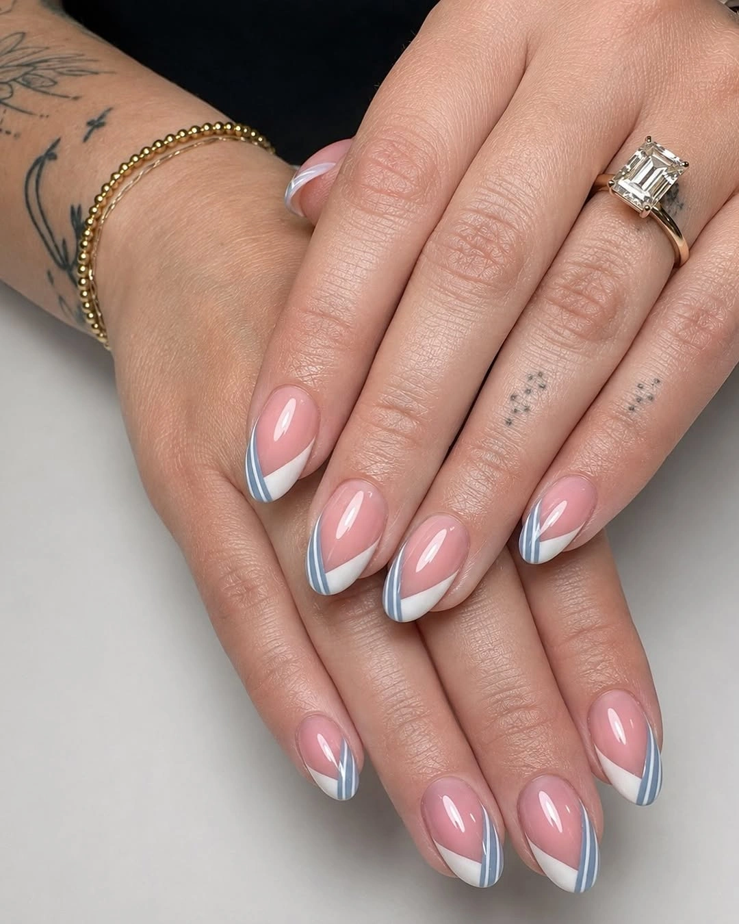 Blush almond nails with crisp white tips and silver edging
