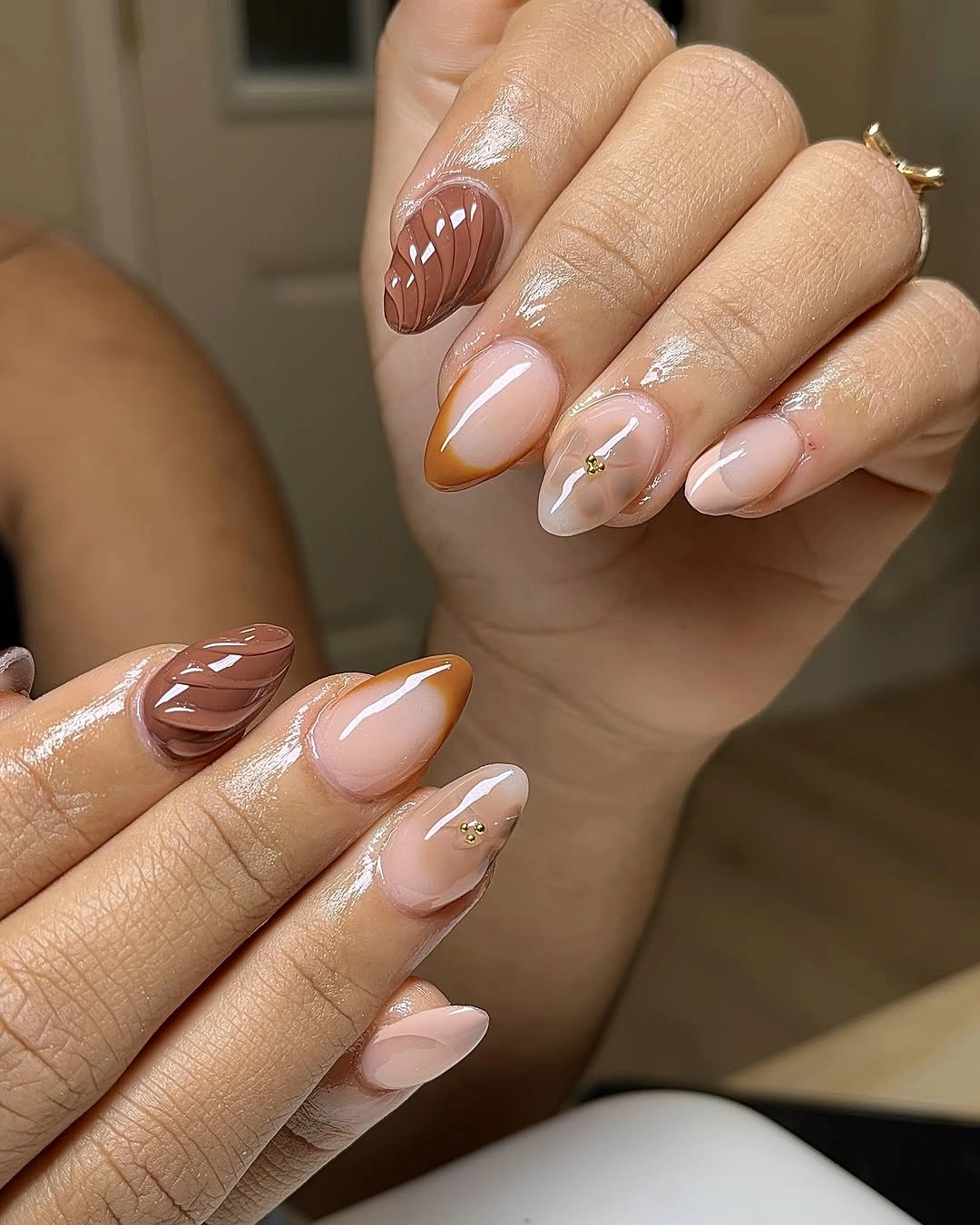Nude pink short almond nails with chocolate curved accents