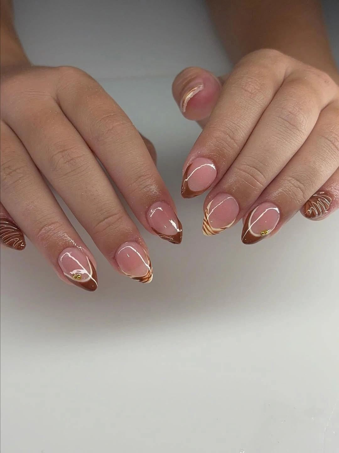 Sheer pink short almond nails with fine peach and white lines