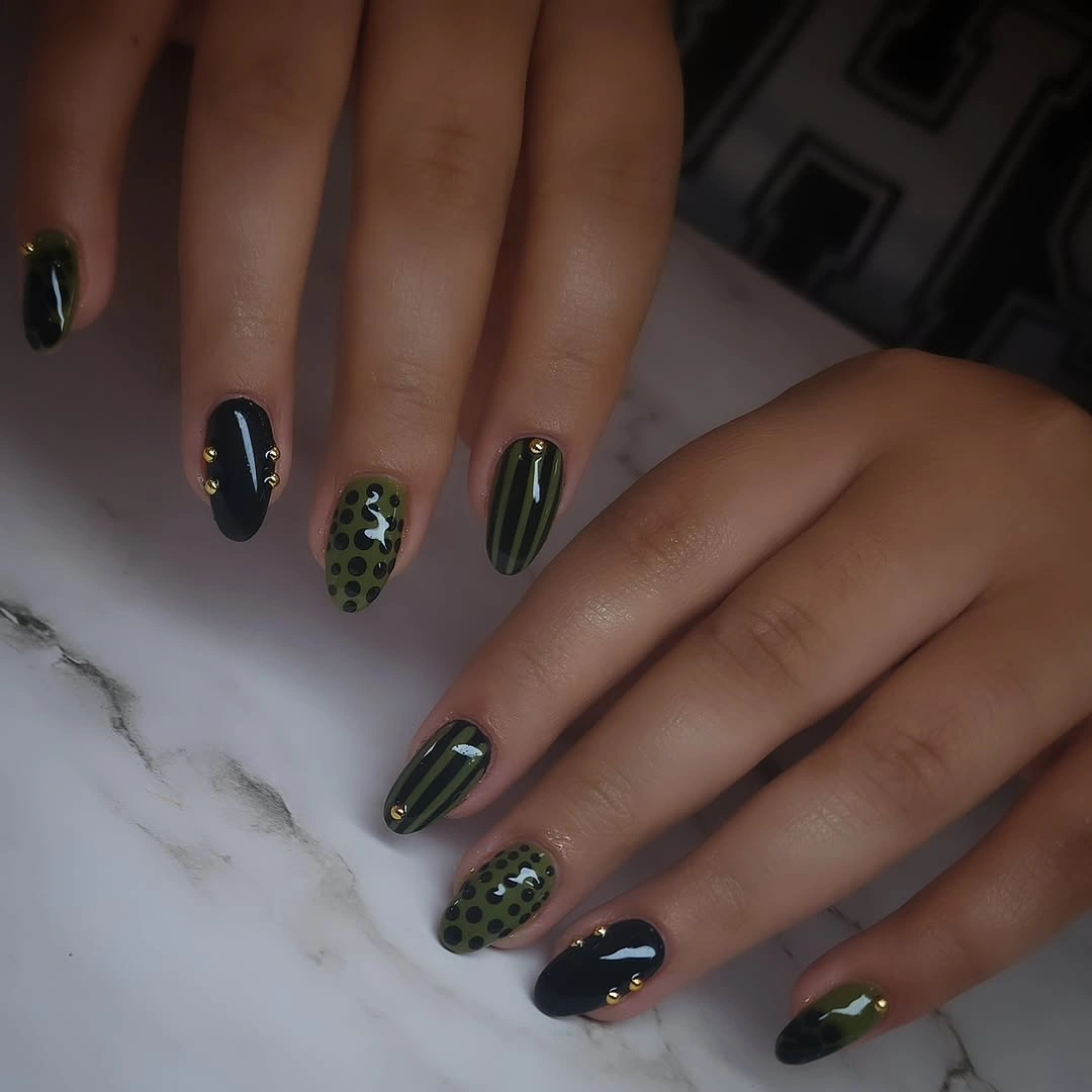 Glossy dark green and black medium almond nails with olive details