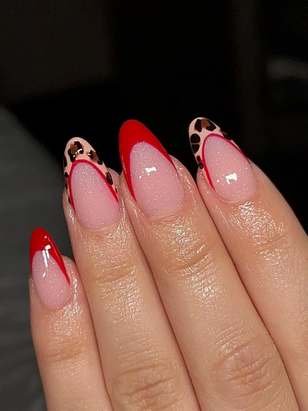 Short almond nails with red French tips and spotted accents