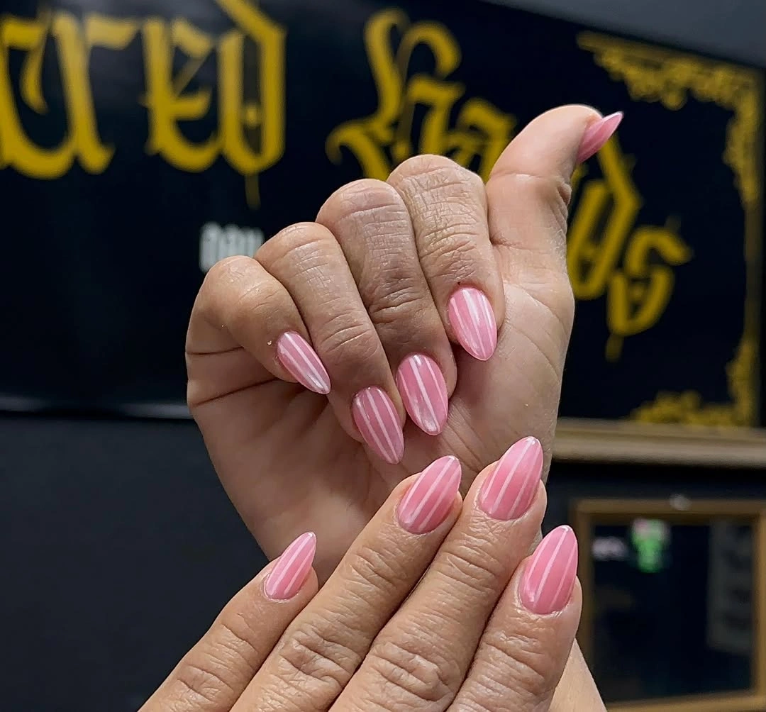Short almond nails in several glossy soft pink tones