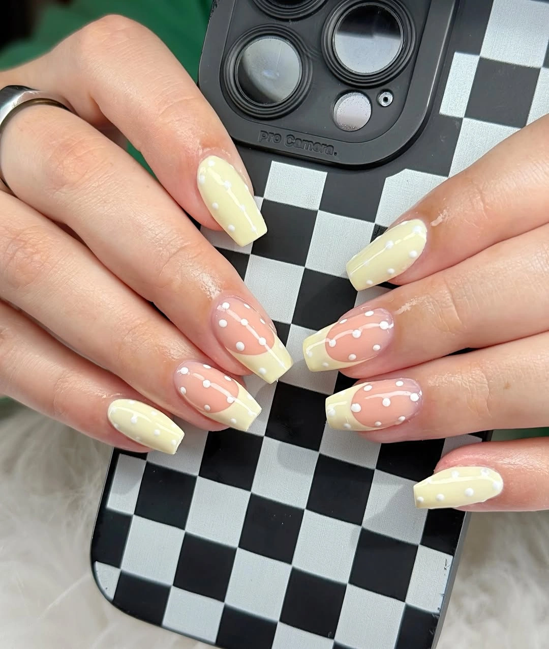 Short square nails with pale yellow French tips and white dots