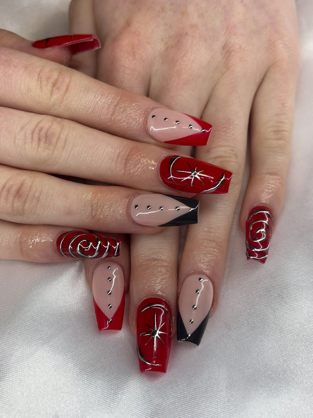 Long square red black nude nails with silver starburst art