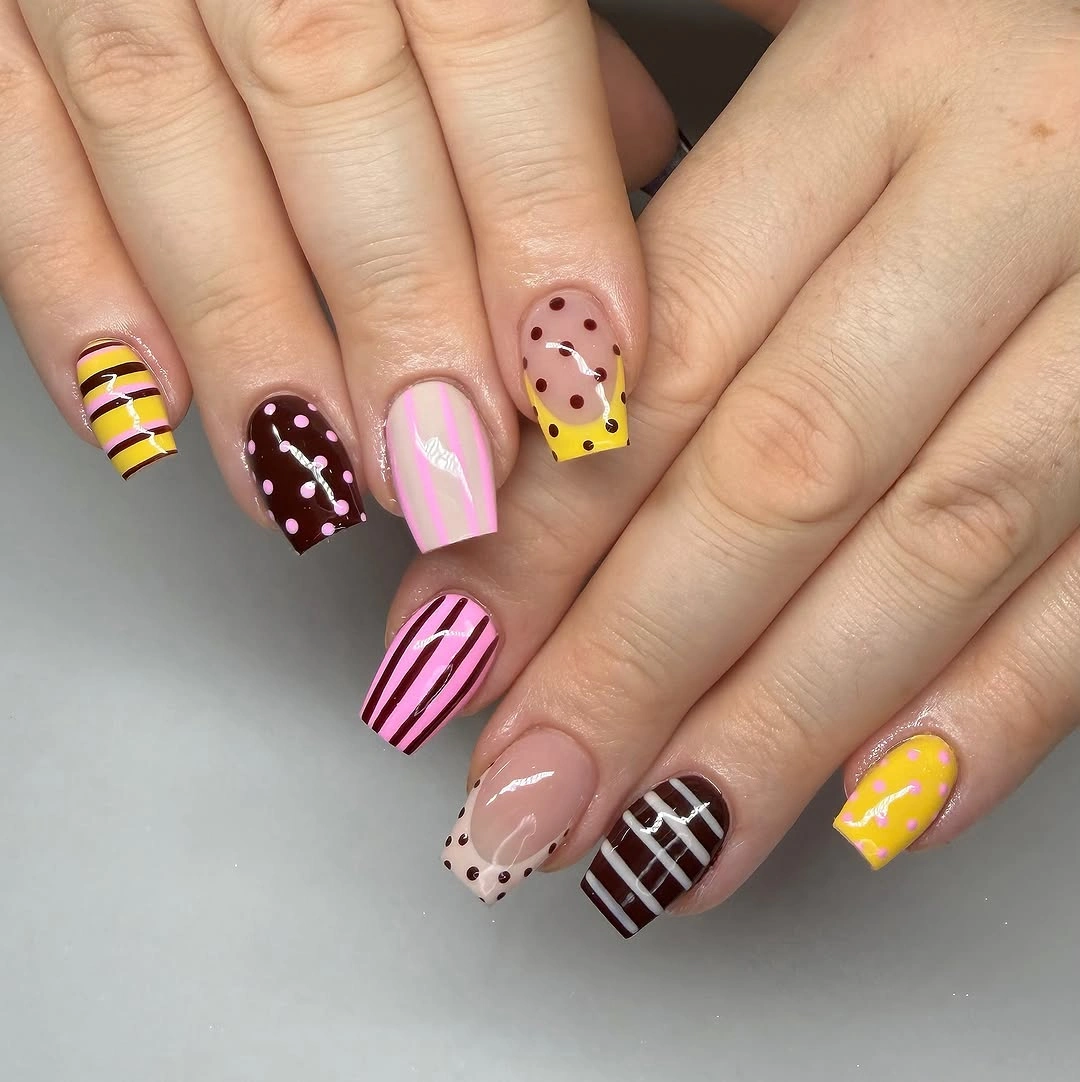 Short square nails with yellow burgundy pink stripes and dots