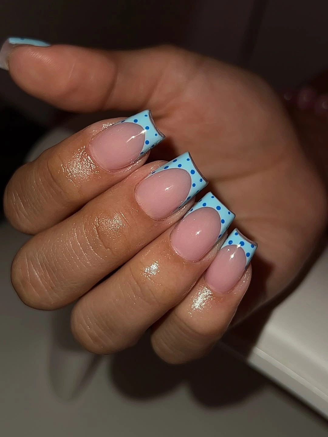 Short pink square nails with pale blue tips and blue dots