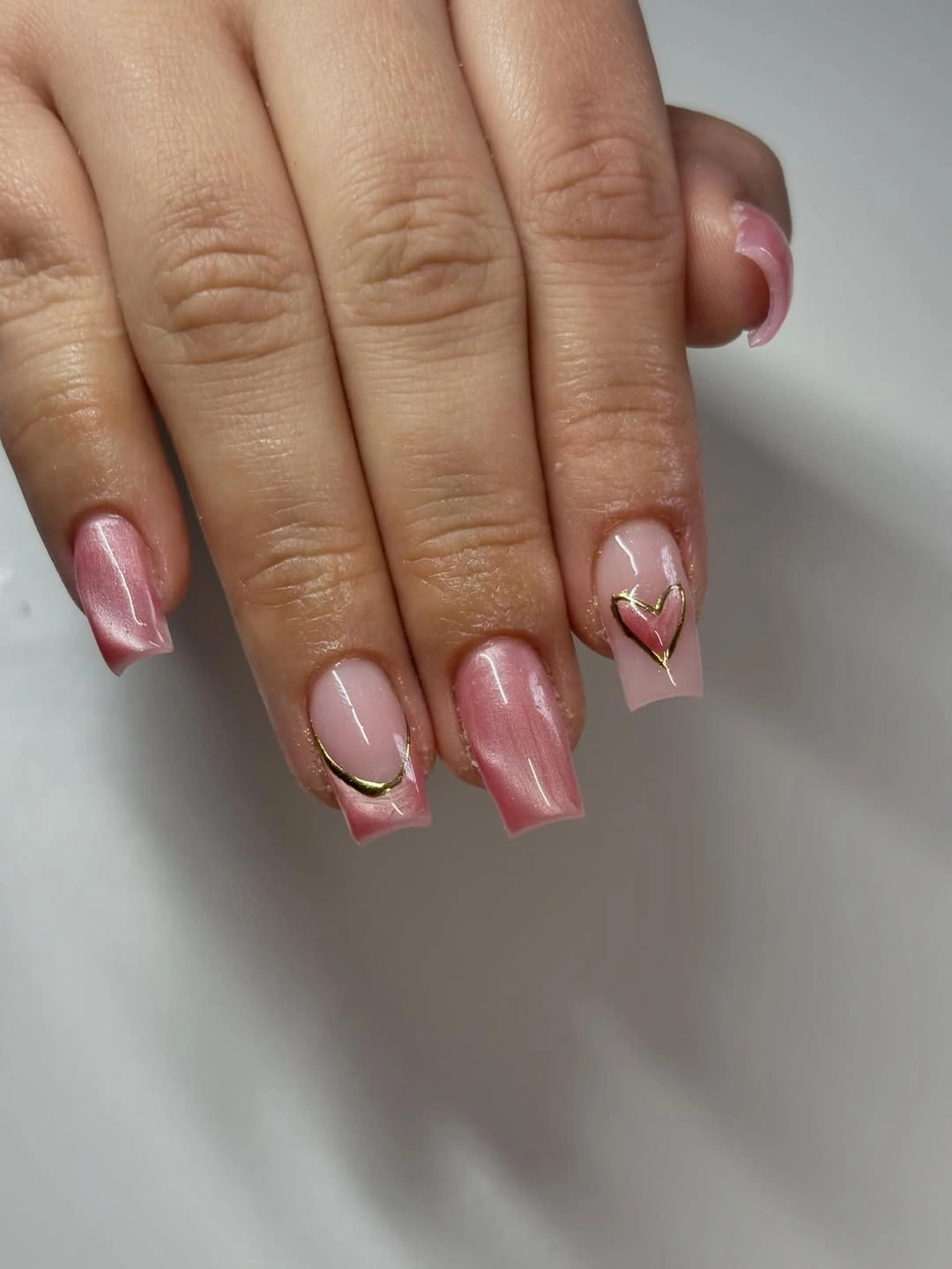 Short rose pink square nails with thin gold curved outlines