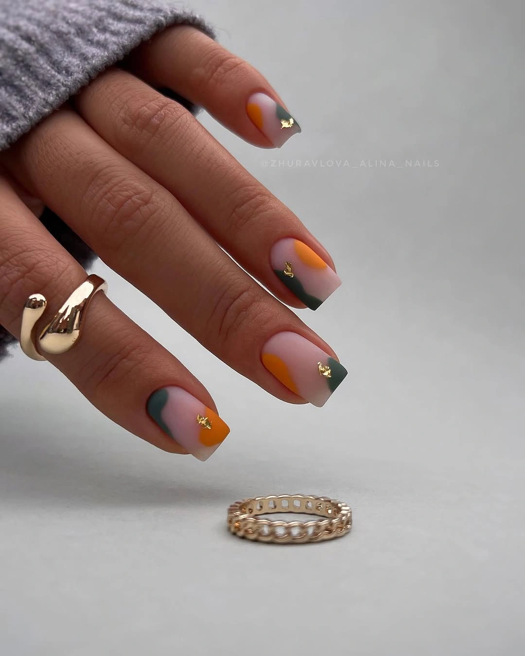 Medium square nails in gray mauve blue and orange curves with small gold-toned accents