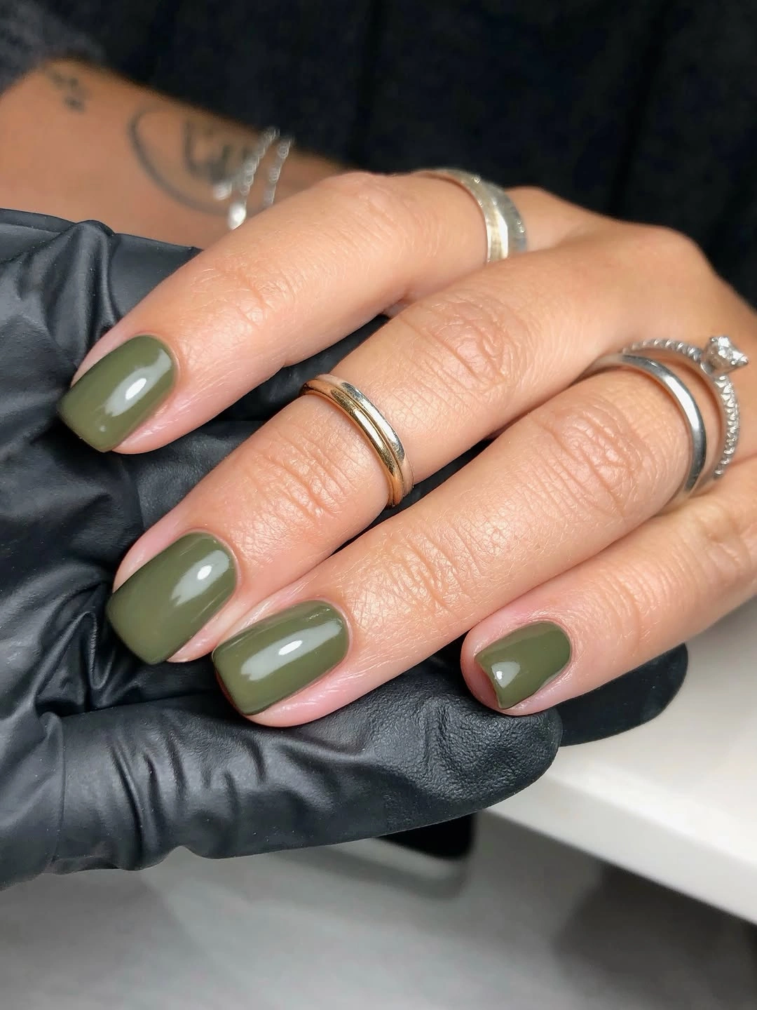 Muted olive green almond-square nails with open nude diagonal sections