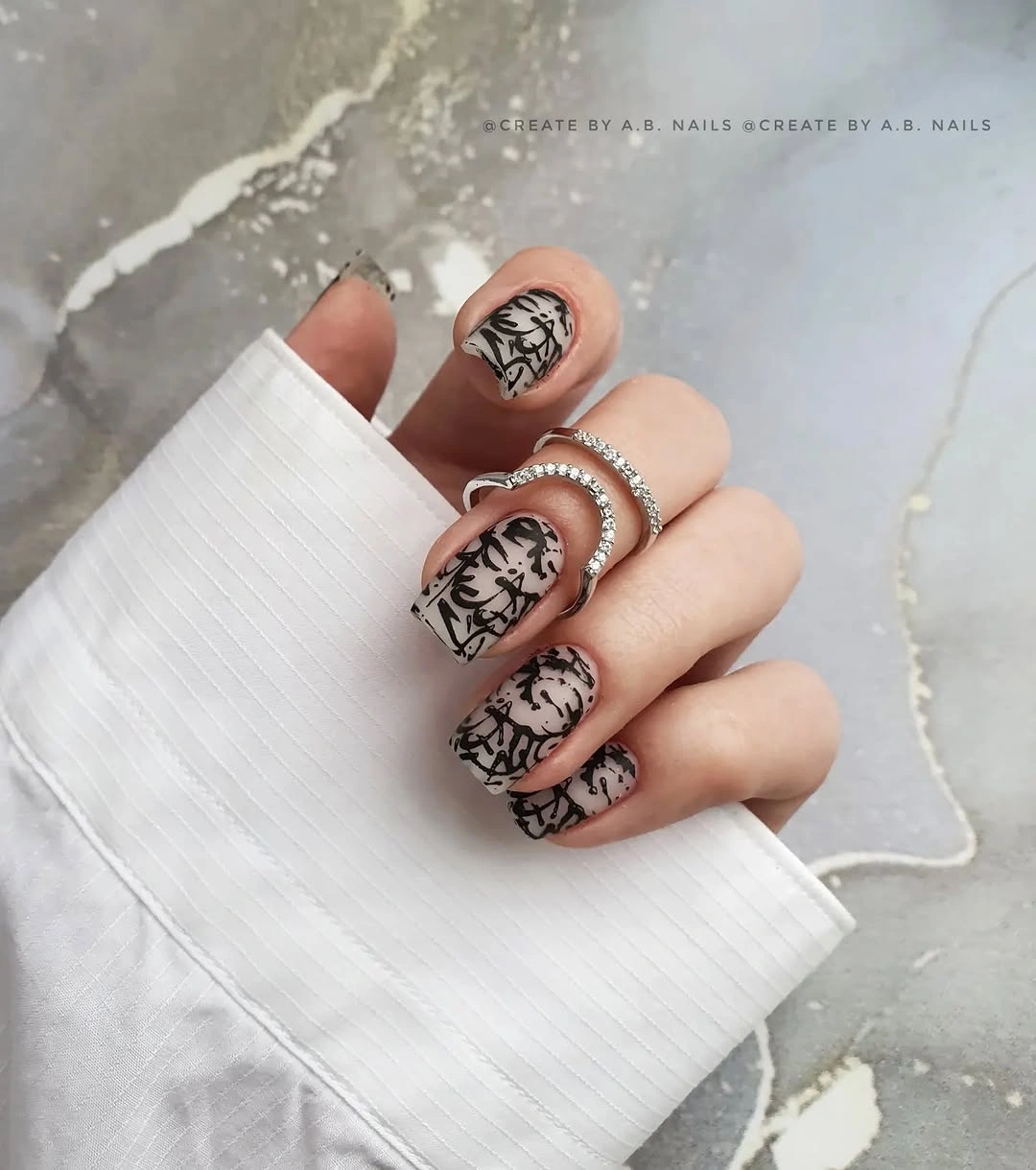 Medium nude pink square nails with fine black botanical-style linework