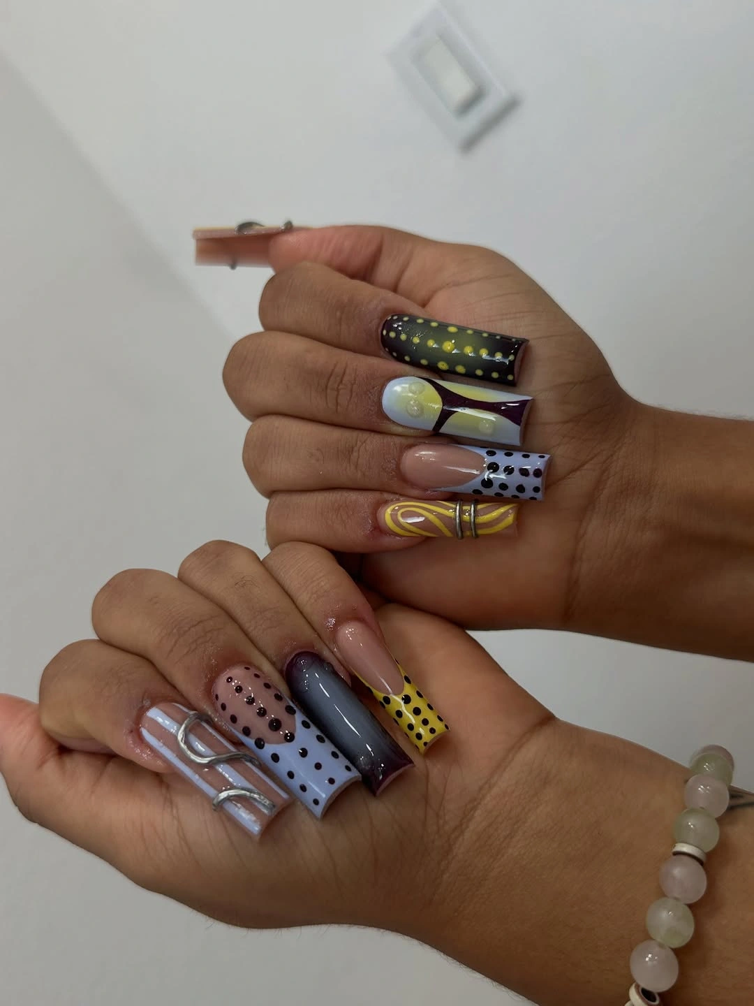 Long square nails with gray yellow lavender and black graphic panels grids and dots