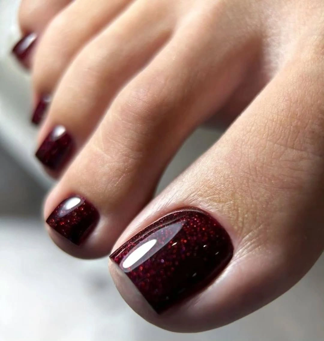 Deep burgundy toes with subtle red reflective shimmer