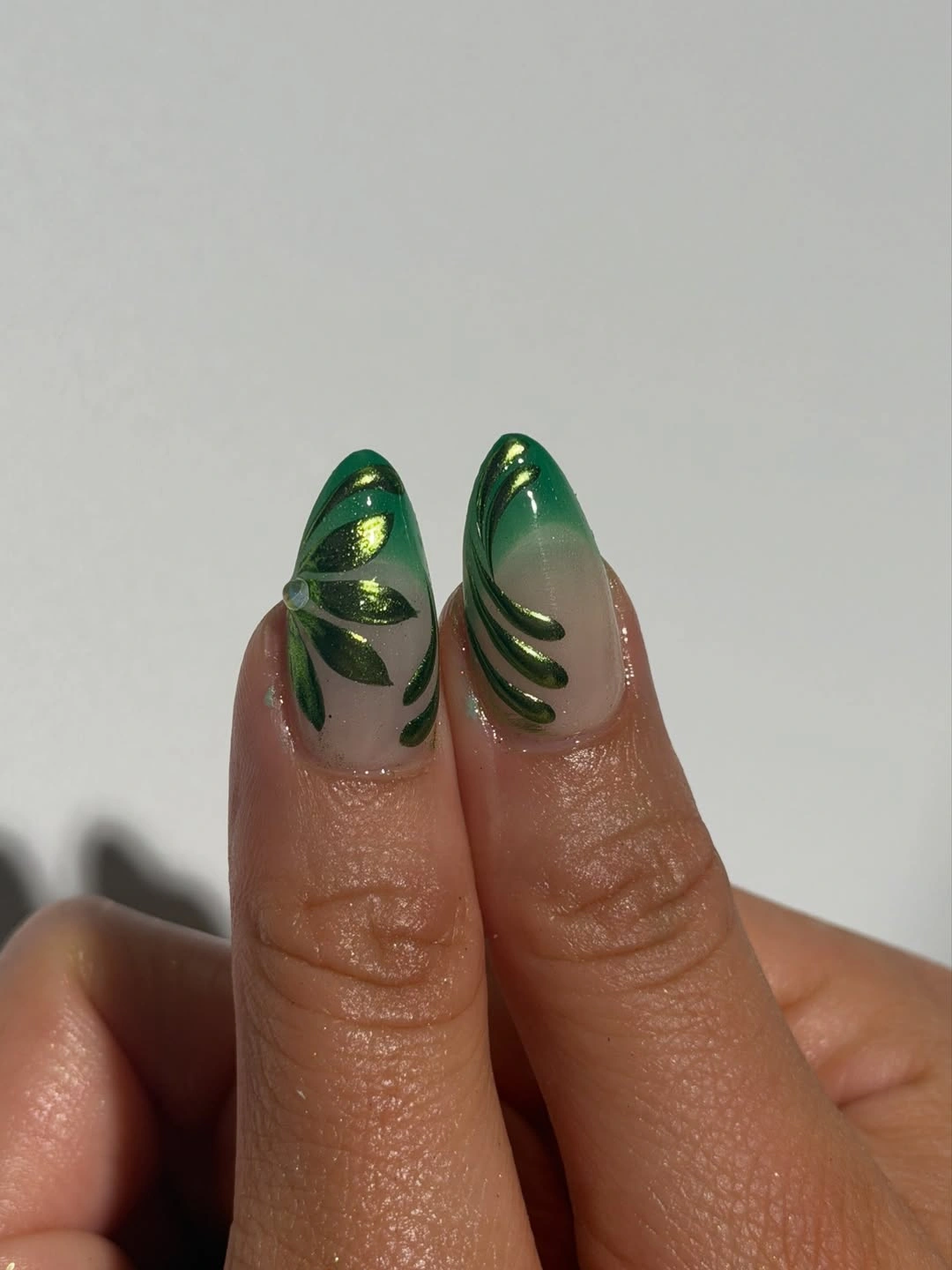 Medium almond nude nails with deep green curved lines