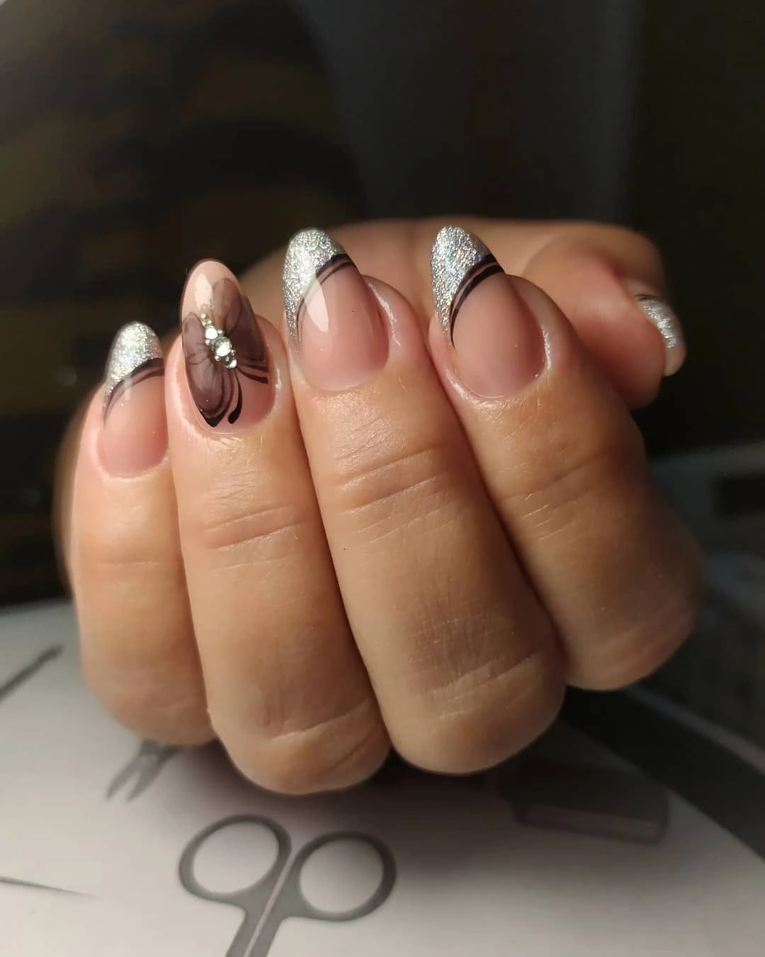 Short nude nails with narrow silver textured tips and dark accent