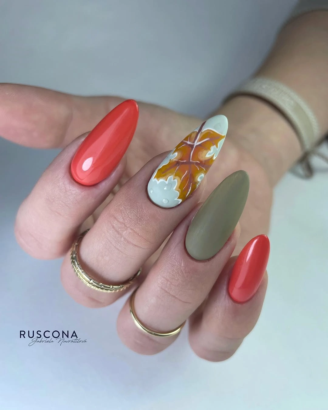 Medium rounded coral sage nails with one pale decorated accent