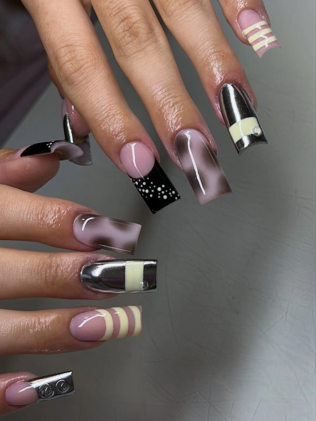 Long mauve square nails with dark reflective panels and pale stripes