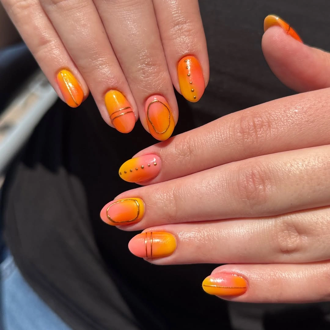 Short rounded orange nails with curved yellow and red bands