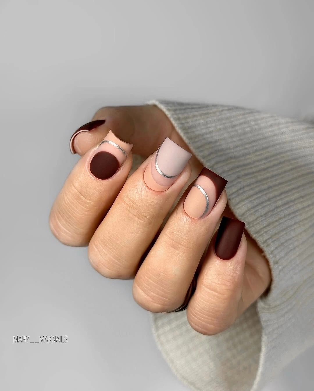 Short rounded nude nails with chocolate brown edge accents