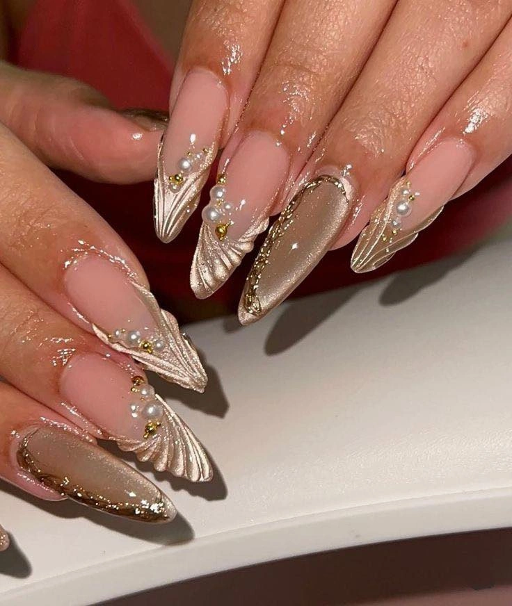 Pointed nude nails with champagne fan tips and pearl beads
