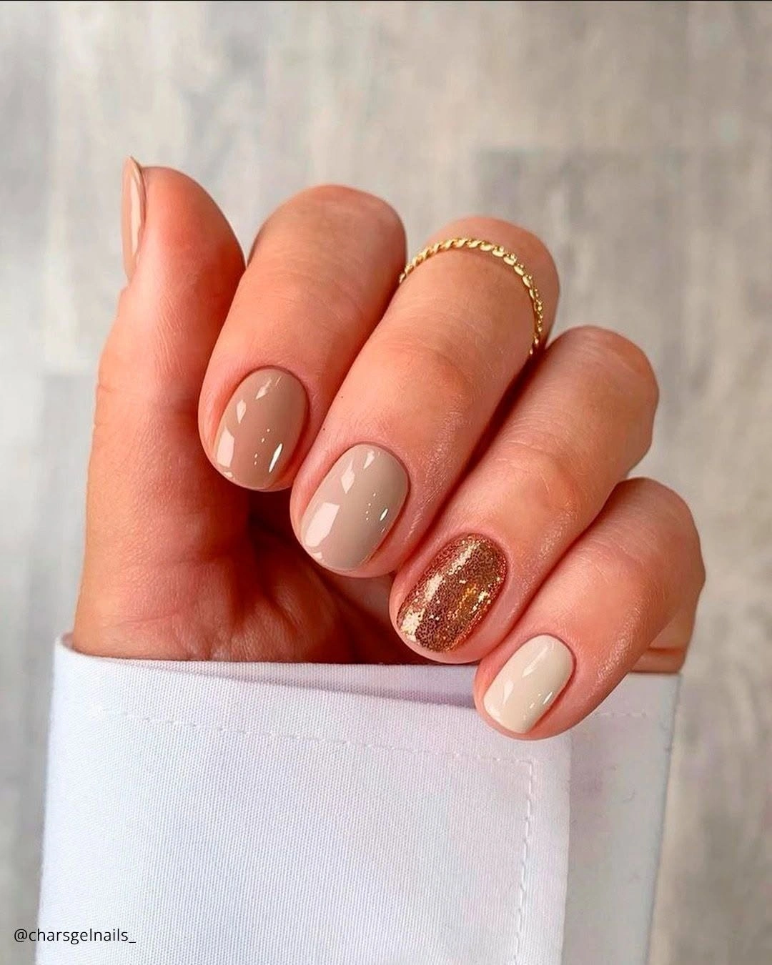 Short neutral rounded nails with one rose gold glitter accent