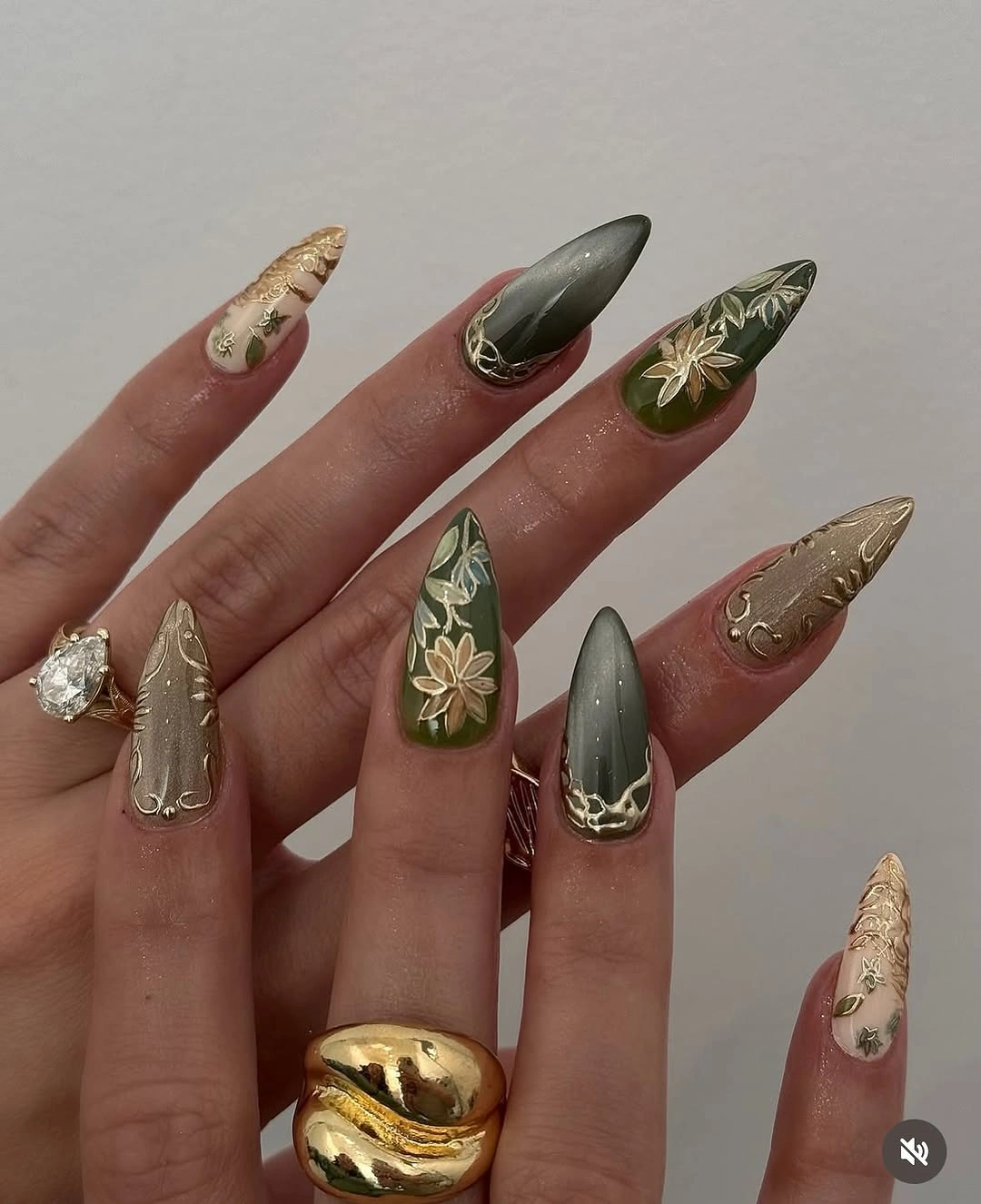 Olive pointed nails with smoky gray and gold botanical accents