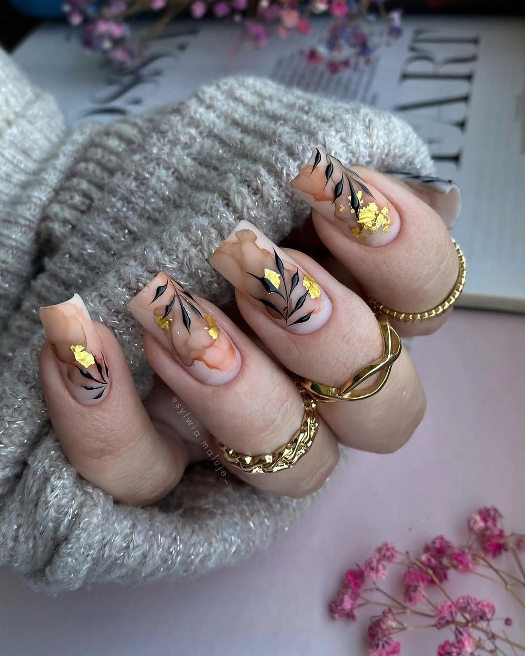 Square nude nails with amber marbling black stems and gold flakes
