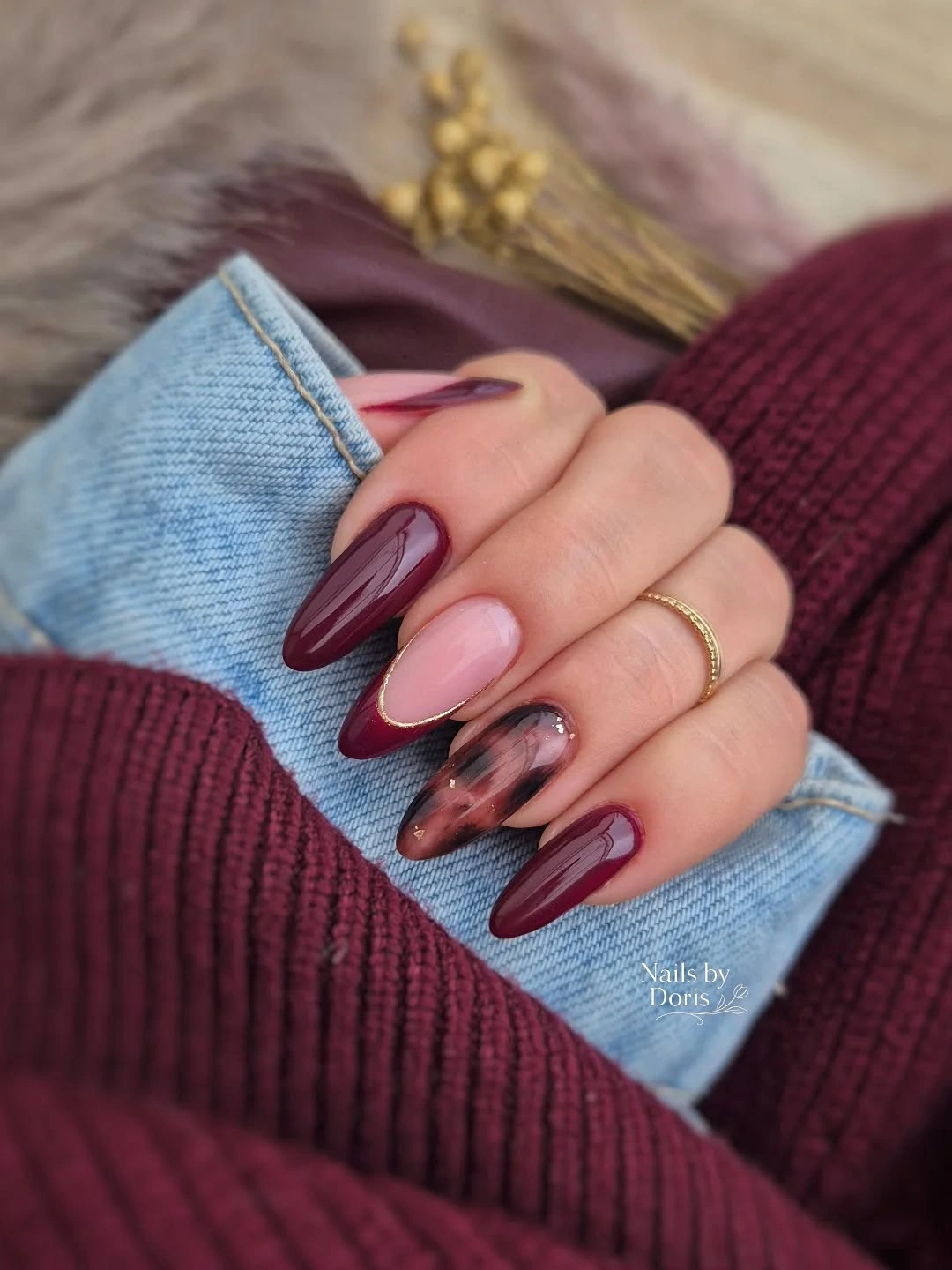 Glossy burgundy almond nails with pink and smoky accents