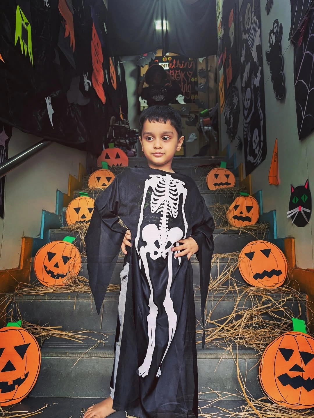 Child skeletal reaper costume in long black robe with white bones
