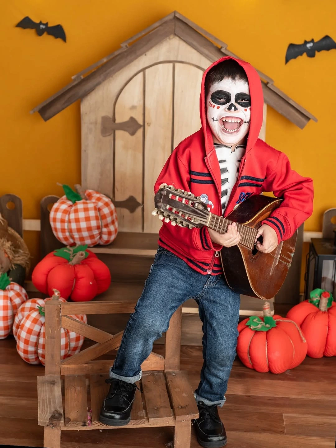 Miguel from Coco child costume with red hoodie, skull makeup, and guitar