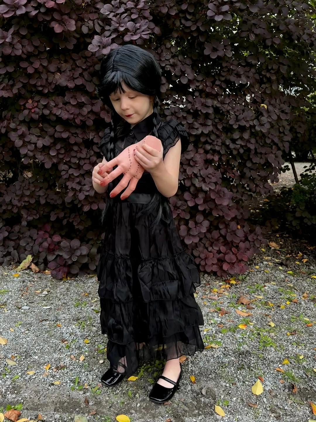 Wednesday Addams child costume in black tiered dress and dark bob