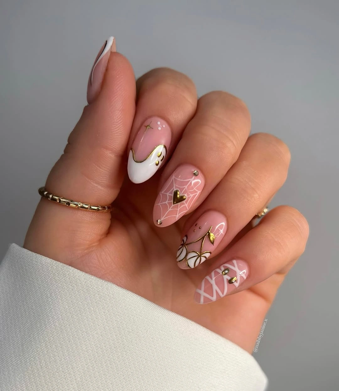 Nude almond nails with white web lines and fine gold accents