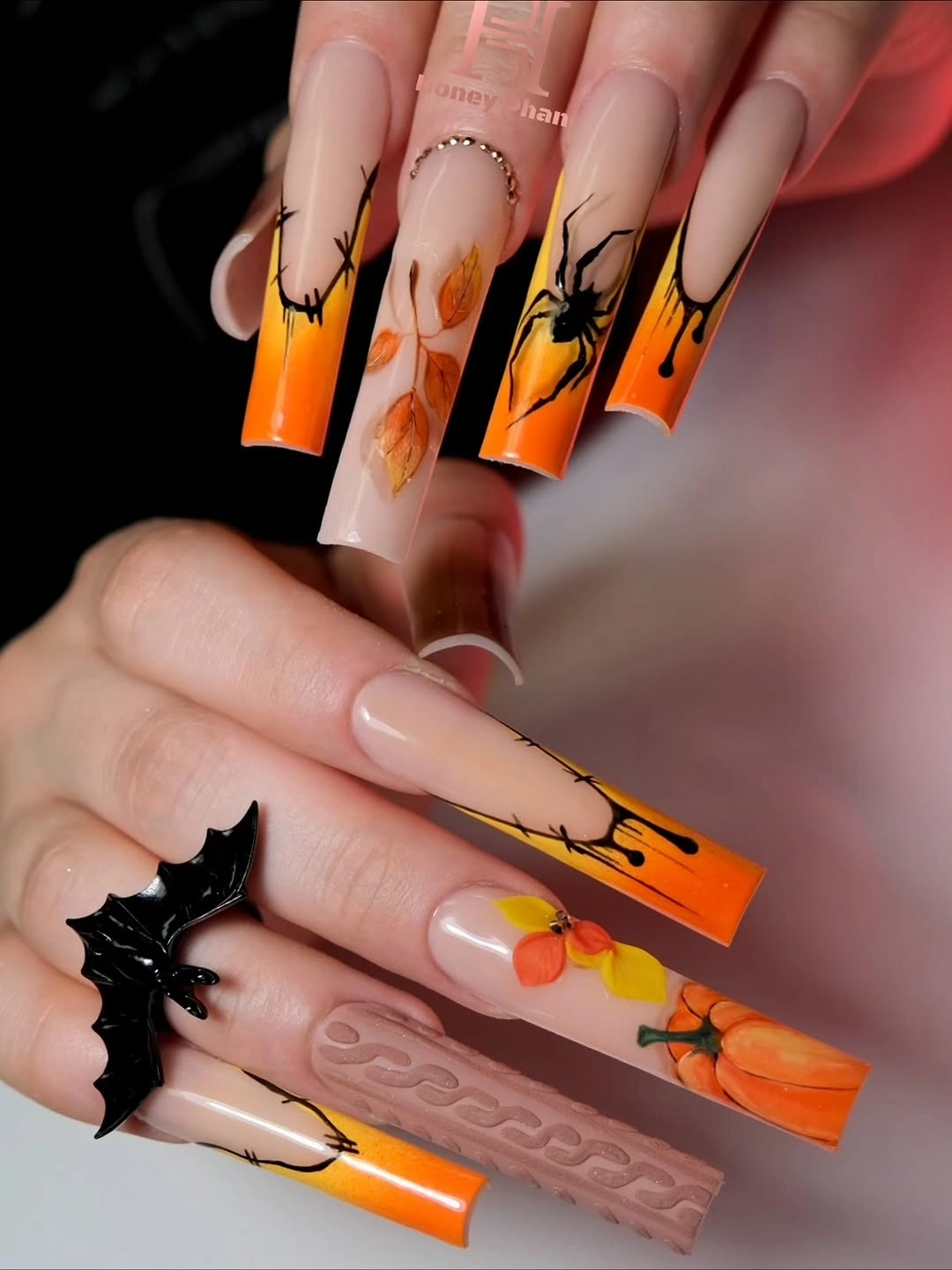 Long square nails with orange tips, stitches, bats, and pumpkin art