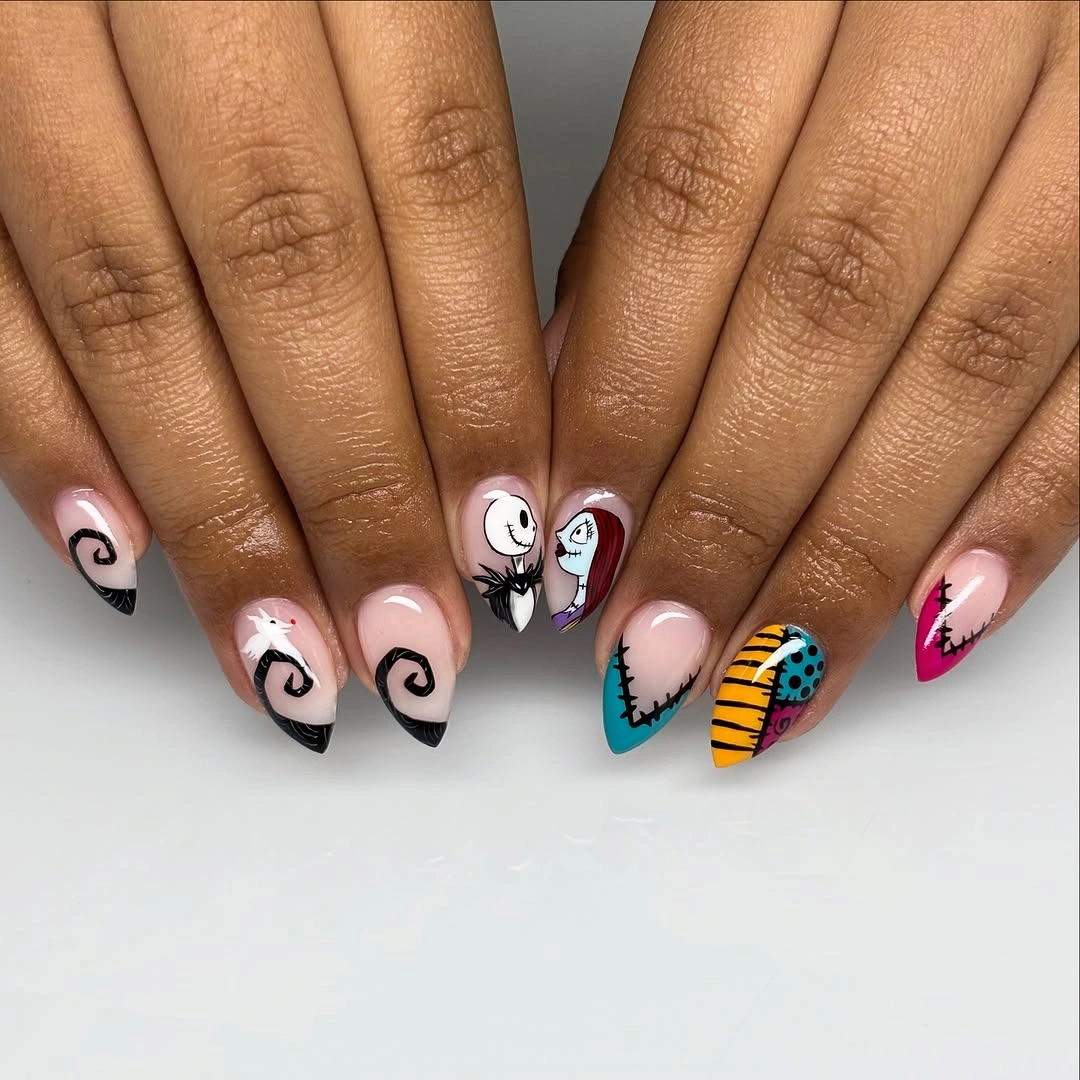 Almond nails with black tips, spirals, stitched patches, and faces