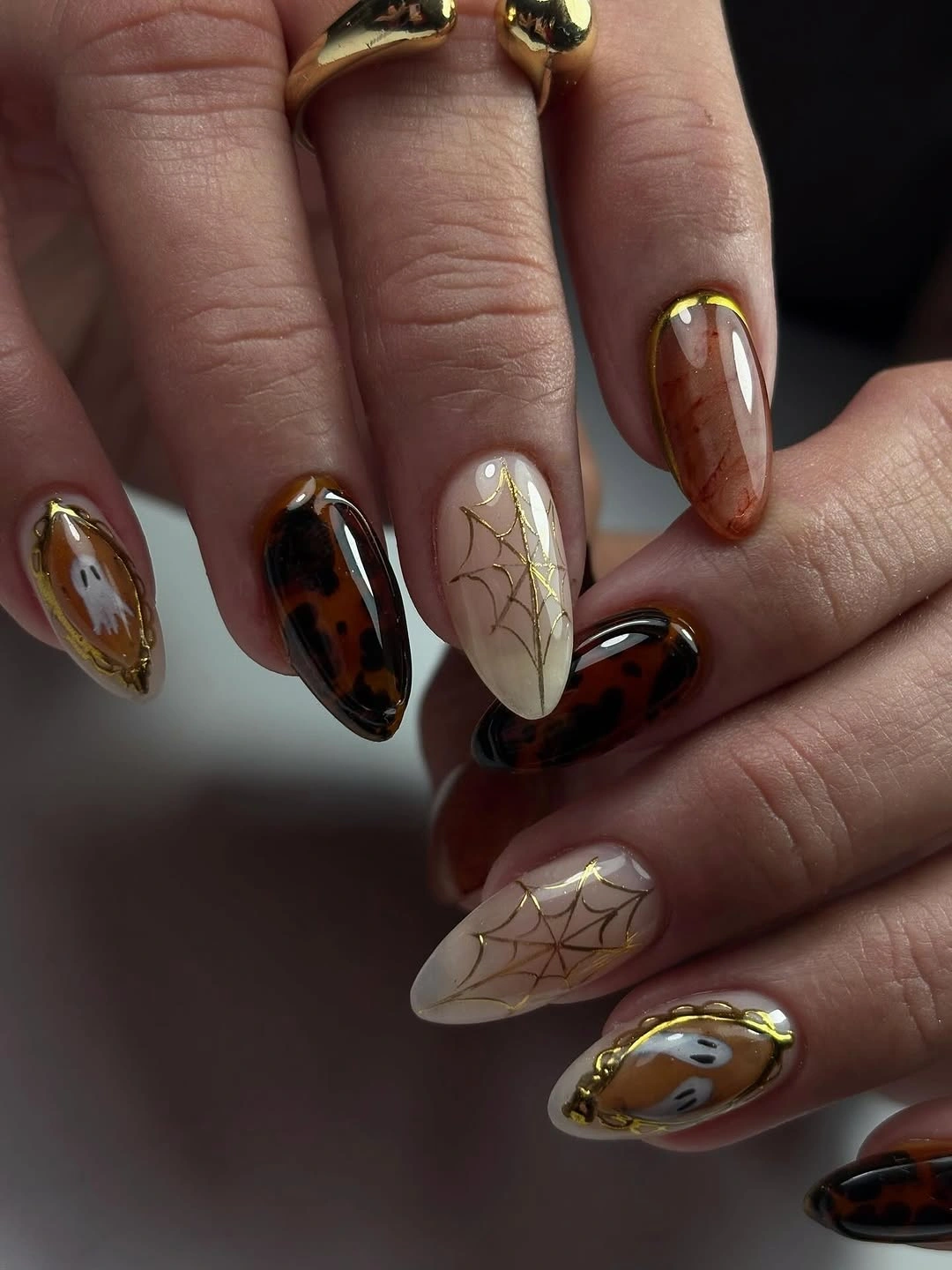 Amber almond nails with gold spiderweb and dark translucent panels
