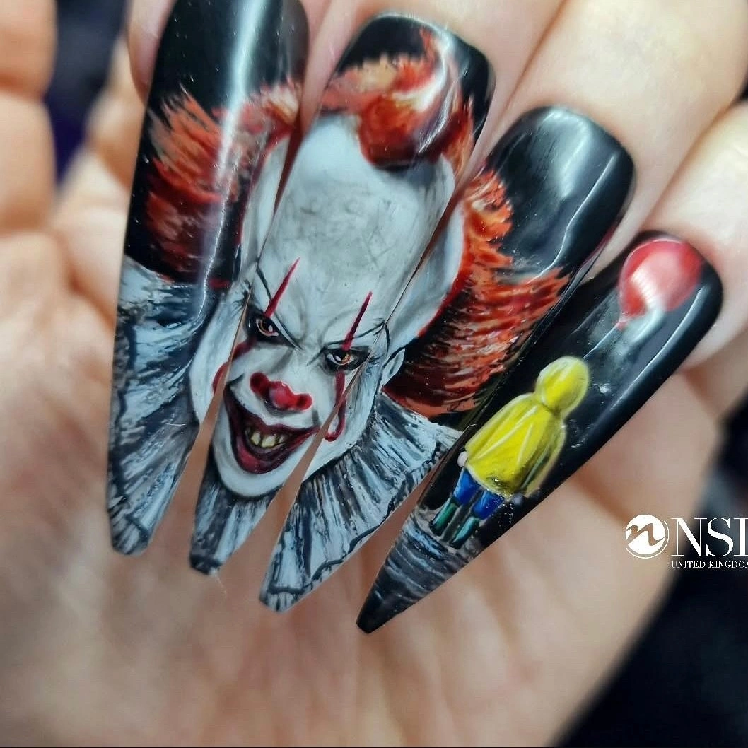 Dark stiletto nails with horror portraits and red yellow accents