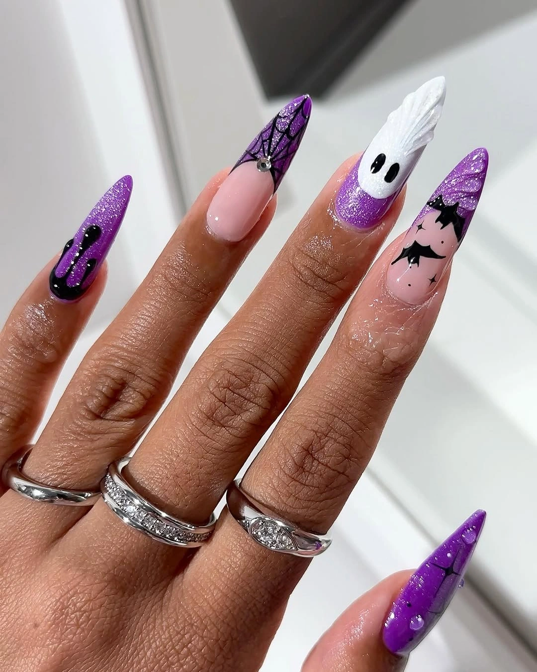 Purple glitter stilettos with webs, bats, and white ghost art