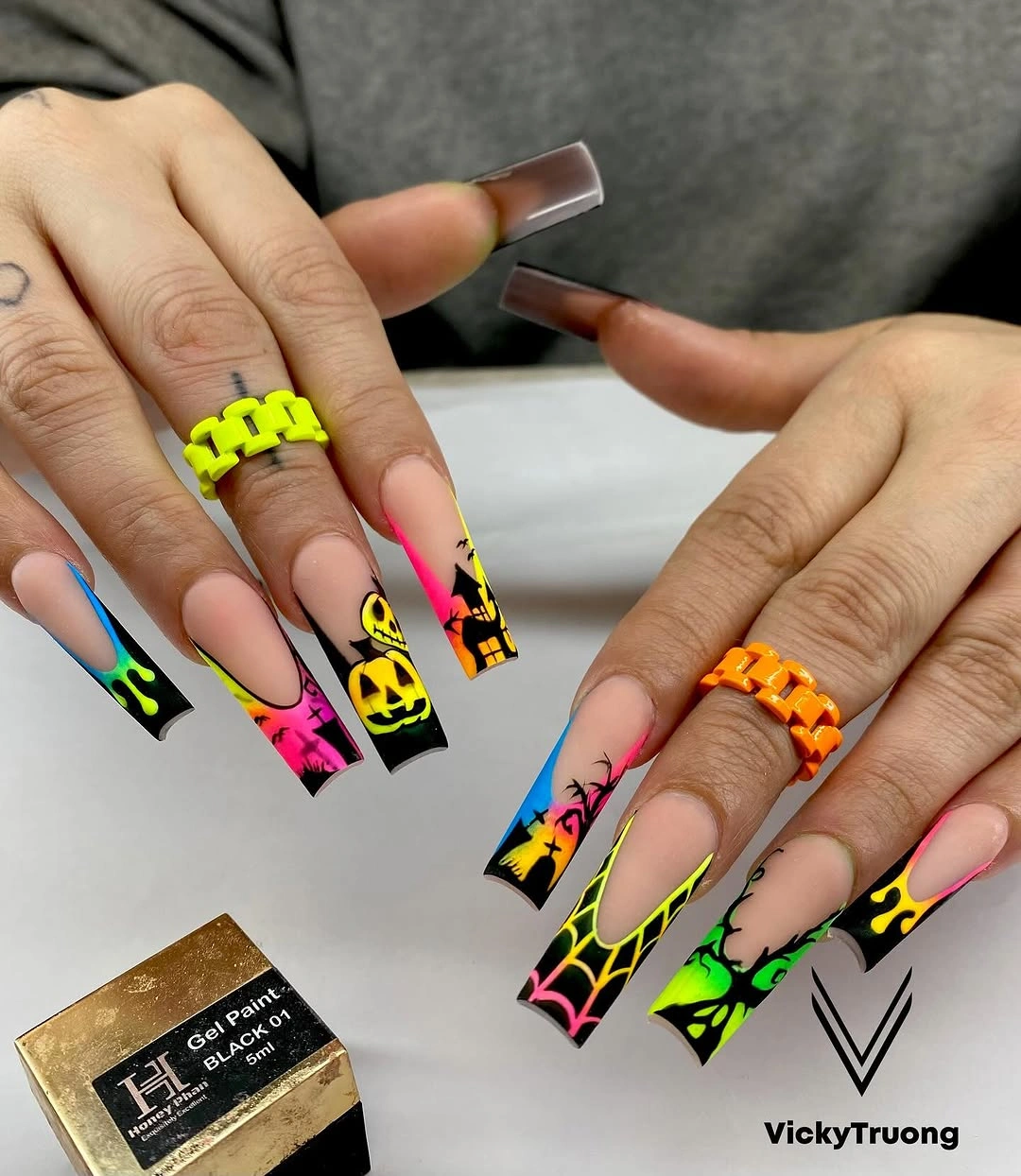 Neon square nails with pumpkin faces, webs, and color blocks