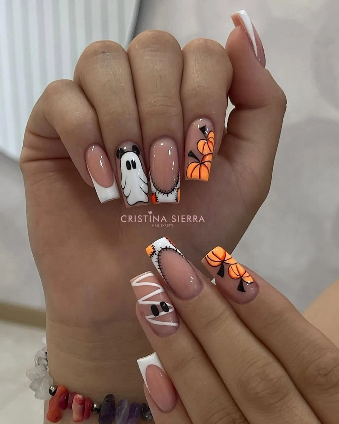 Medium square nails with small ghosts, pumpkins, and stitched tips
